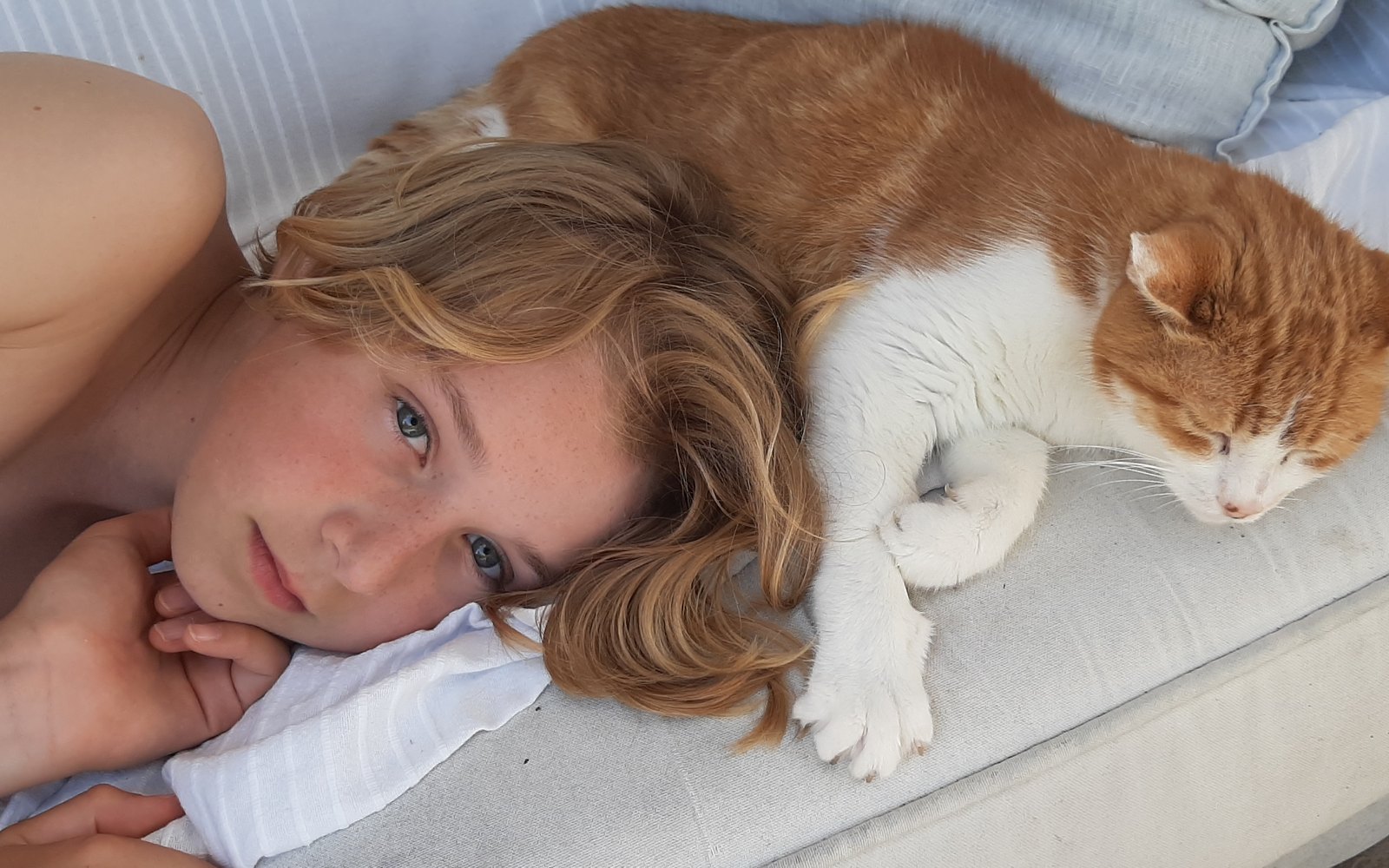 Jeune personne et son chat, allongés côte à côte